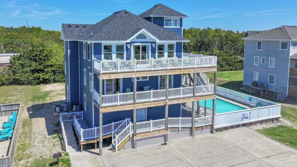A two-story house with a balcony and a swimming pool. - Oceanview Dog Friendly Home with Private Pool, Hot Tub, Elevator, and Game Room (Waves)