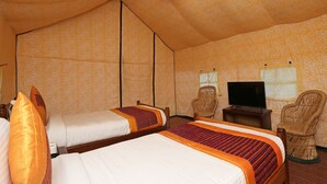 A room with two beds, a television, and two wicker chairs. - OYO 9485 Swiss Camps (Kullu)