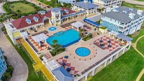 Un complexe hôtelier doté d’une grande piscine, de plusieurs espaces de détente en plein air et de plusieurs bâtiments avec balcons.