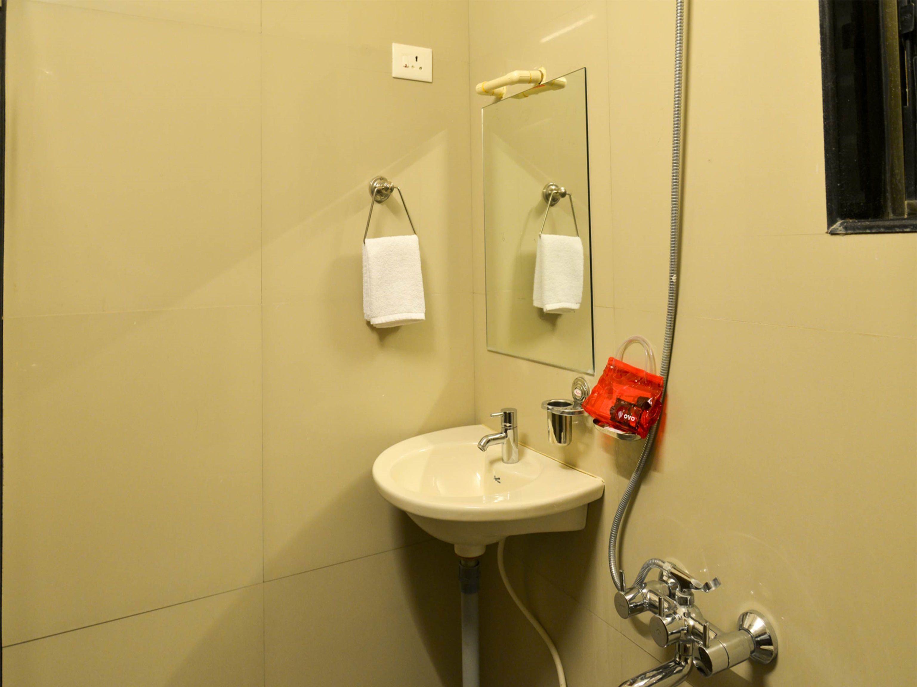 A bathroom with a sink, mirror, towel rack, and shower.
