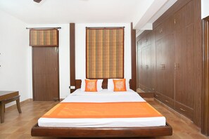 A bedroom with a wooden bed, a wardrobe, and a bench. - OYO 10976 Home Cheerful 2BHK Scenic Barog (Solan)