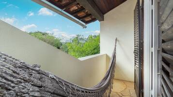 Una hamaca en un rincón de la habitación con vistas al verdor exterior.