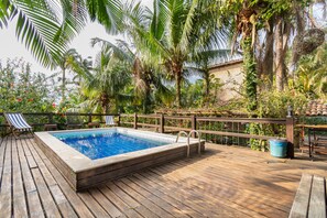 Una piscina al aire libre, sillones reclinables de piscina
