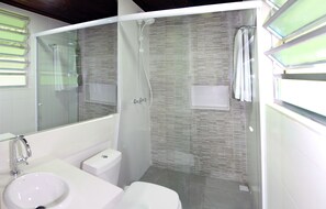 A modern bathroom with a glass-enclosed shower, a white sink, and a toilet. - Hotel Daniela (Itatiaia)