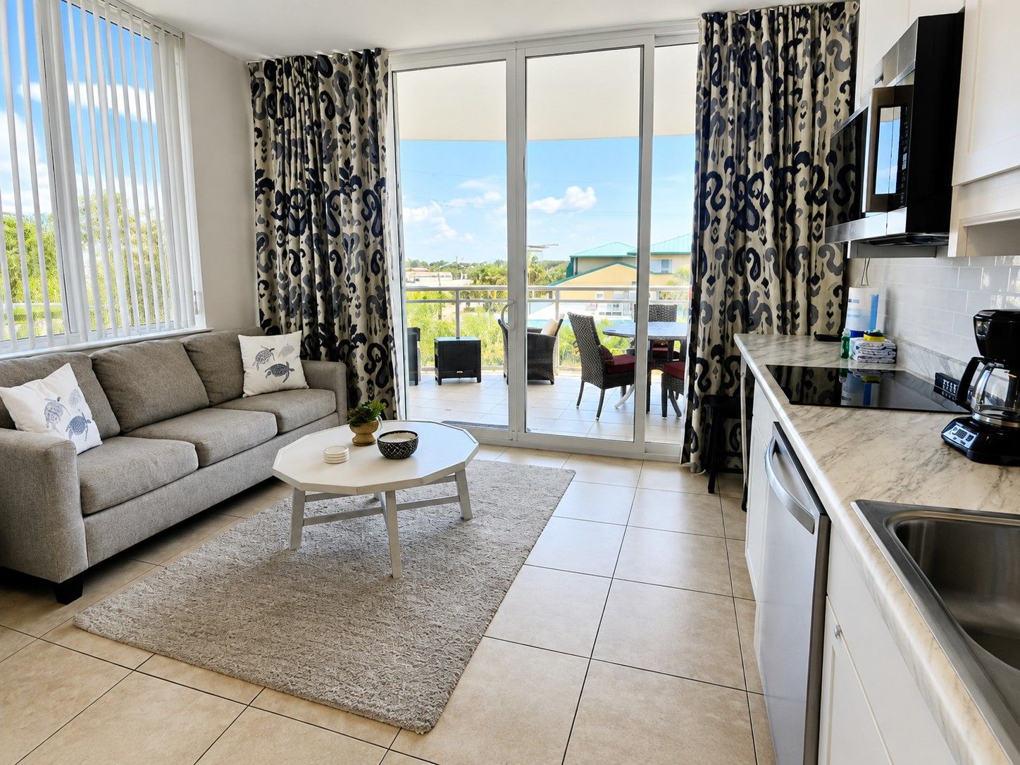 A modern living room with a sofa, coffee table, and a view to an outdoor patio.