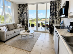 A modern living room with a sofa, coffee table, and a view to an outdoor patio. - V310 Cozy Gulf View Villa w/Private Balcony Washer/Dryer & Free Beach Chairs (Fort Walton Beach)