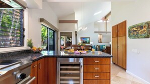 Een moderne keuken met een centraal eiland, roestvrijstalen apparatuur en houten keukenkastjes.