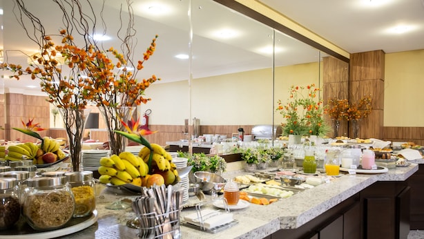 A buffet with various food items and beverages, including fruits, vegetables, and a variety of dishes. - Barbur Center Hotel (Ponta Grossa)