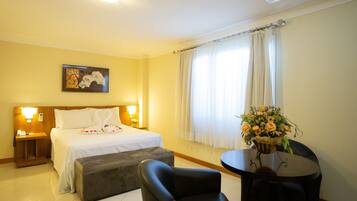 Una habitación de hotel con una cama, un escritorio, una silla y una ventana con cortinas.
