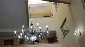 A multi-level hotel lobby with a chandelier, seating areas, and a reception desk. - Barbur Center Hotel (Ponta Grossa)
