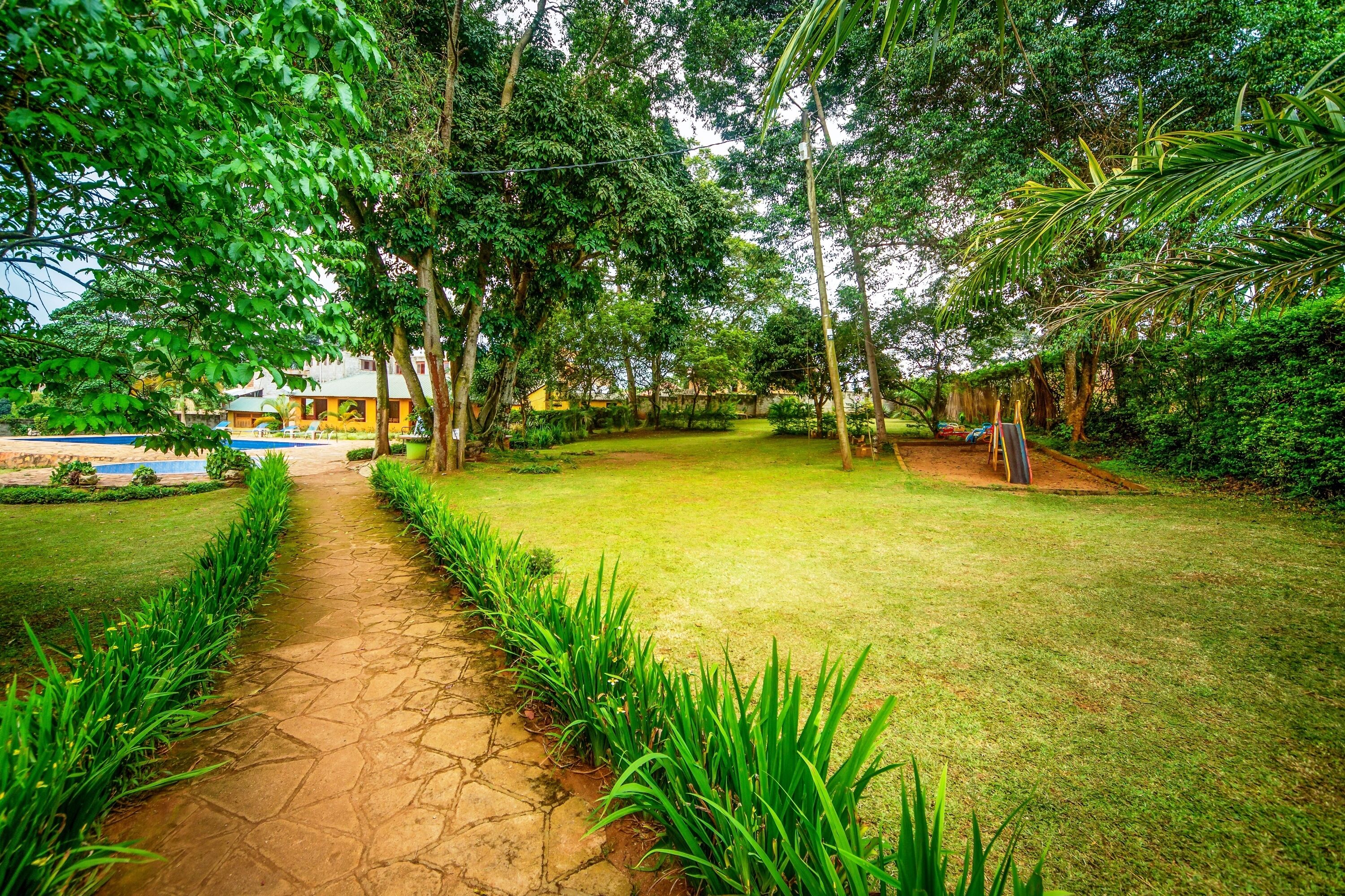 A well-maintained garden with a stone pathway leading to a pool area.