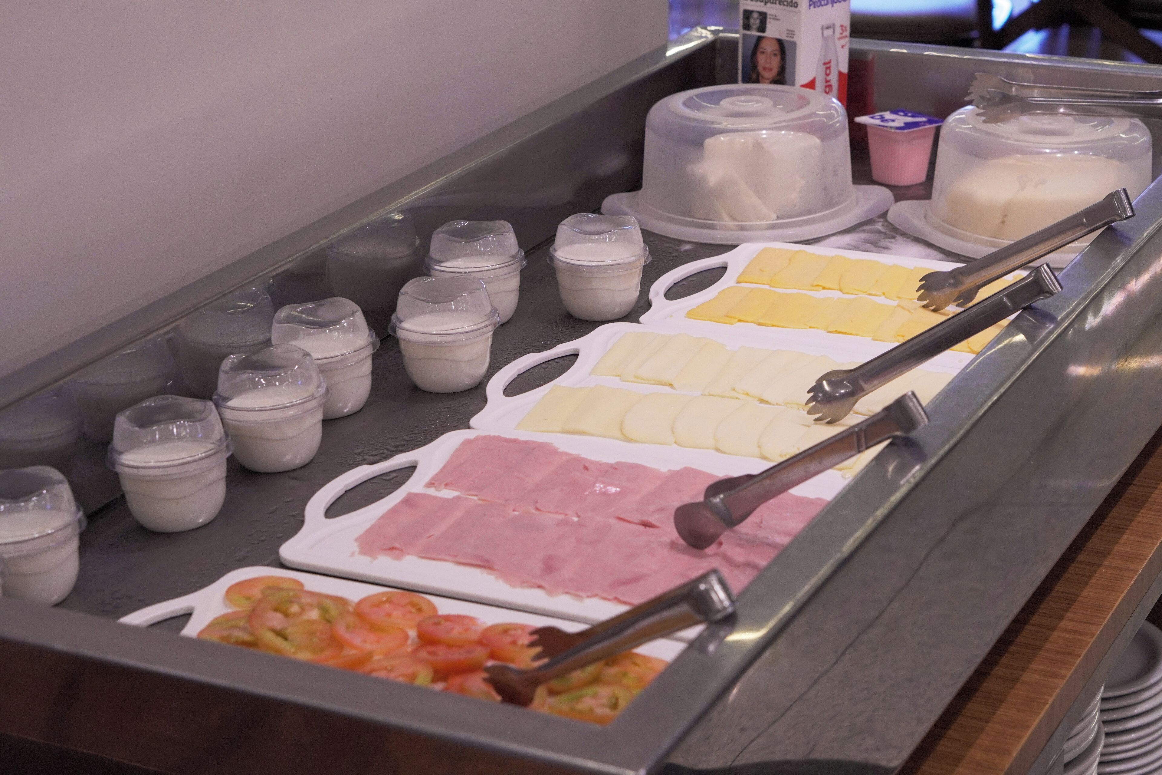Un buffet proposant une variété d’aliments, notamment des tranches de fromage, du jambon et des crevettes.