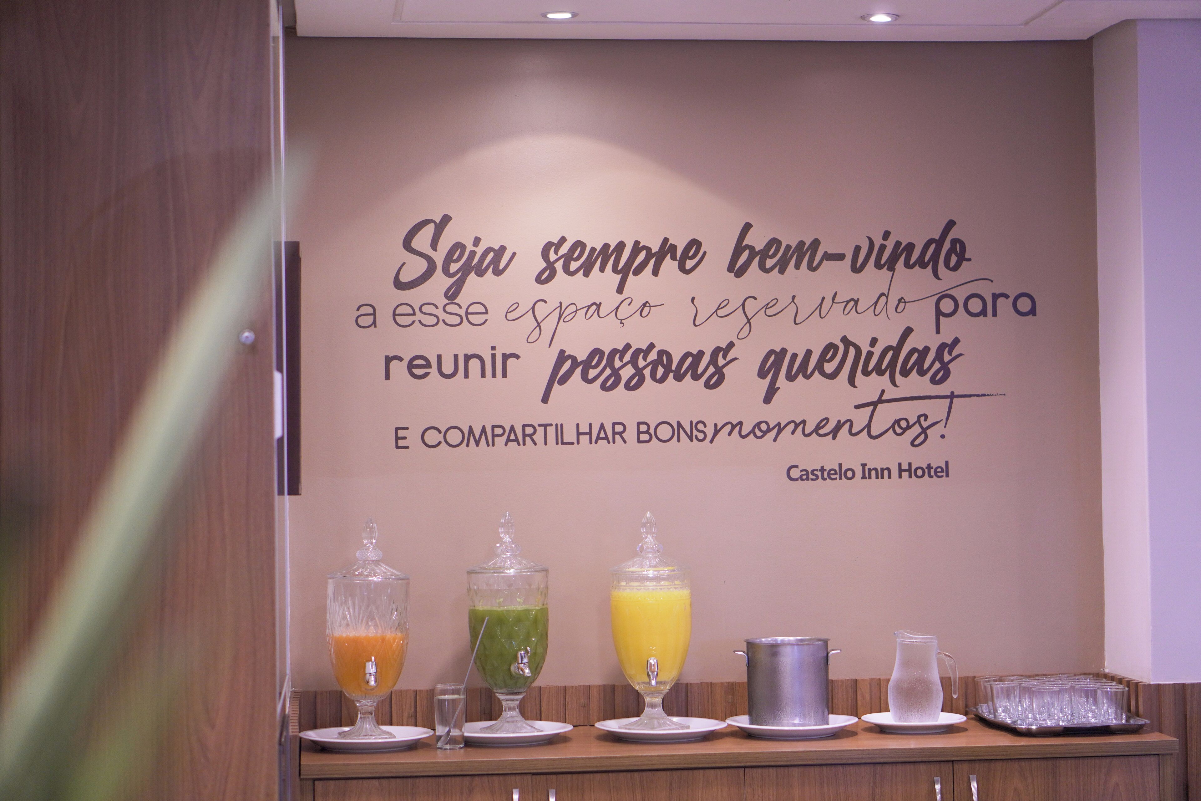 A breakfast bar with a quote on the wall and various beverages.