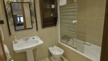 Un baño con lavamanos, bidé y bañera.