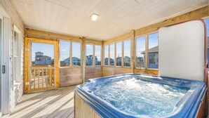 Ein Whirlpool auf einer Holzdiele mit Blick auf Häuser.
