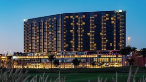 A modern hotel with multiple floors, large windows, and a well-lit facade. - Aloft by Marriott Dubai Creek (Dubai)