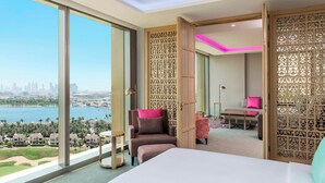 A hotel room with a large window offering a city view, a bed, a chair, and a small table. - Aloft by Marriott Dubai Creek (Dubai)