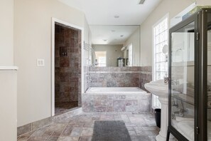Une salle de bain moderne avec une baignoire, une douche à parois de verre et un lavabo sur colonne.
