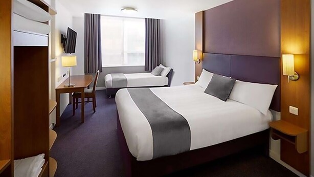 A hotel room with a large bed, a smaller bed, a desk, a chair, a TV, and a window with curtains. - The Magnum Hotel, Sunderland City, Sure Collection by Best Western (Sunderland)