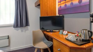 A hotel room with a desk, a television, a coffee maker, and a painting on the wall. - The Magnum Hotel, Sunderland City, Sure Collection by Best Western (Sunderland)