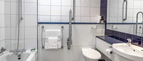 A modern bathroom with a bathtub, toilet, and sink. It includes grab bars and a showerhead.