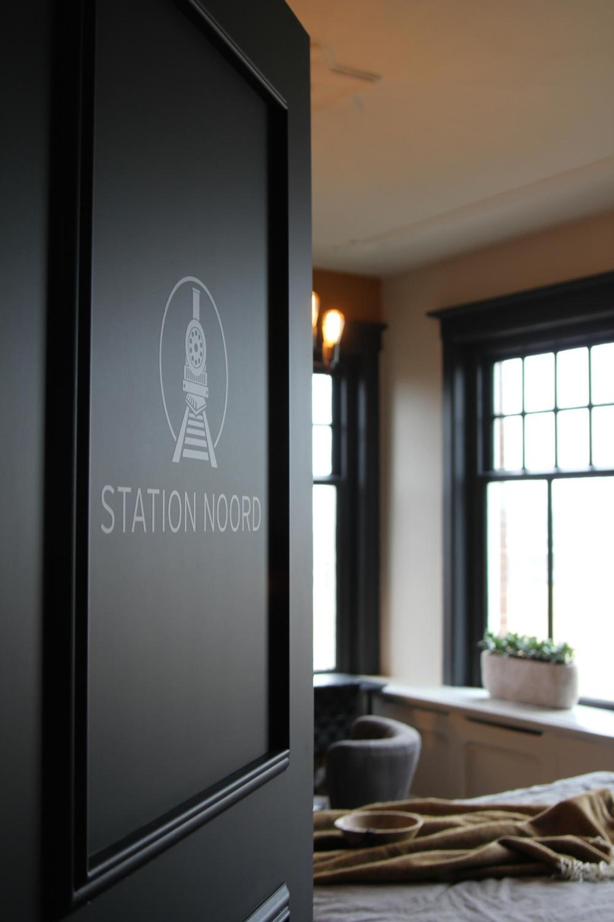 A framed sign with the text "STATION NOORD" and a graphic of a train.