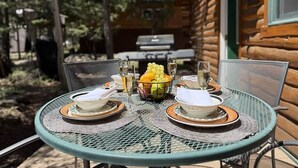 An outdoor dining table set with plates, glasses, and a fruit bowl. - 33 MI to YNP | Private Dock | Firepit (Island Park)