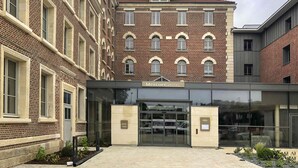 A hotel entrance with a brick facade, large glass doors, and a sign reading "Mercure HOTEL".
