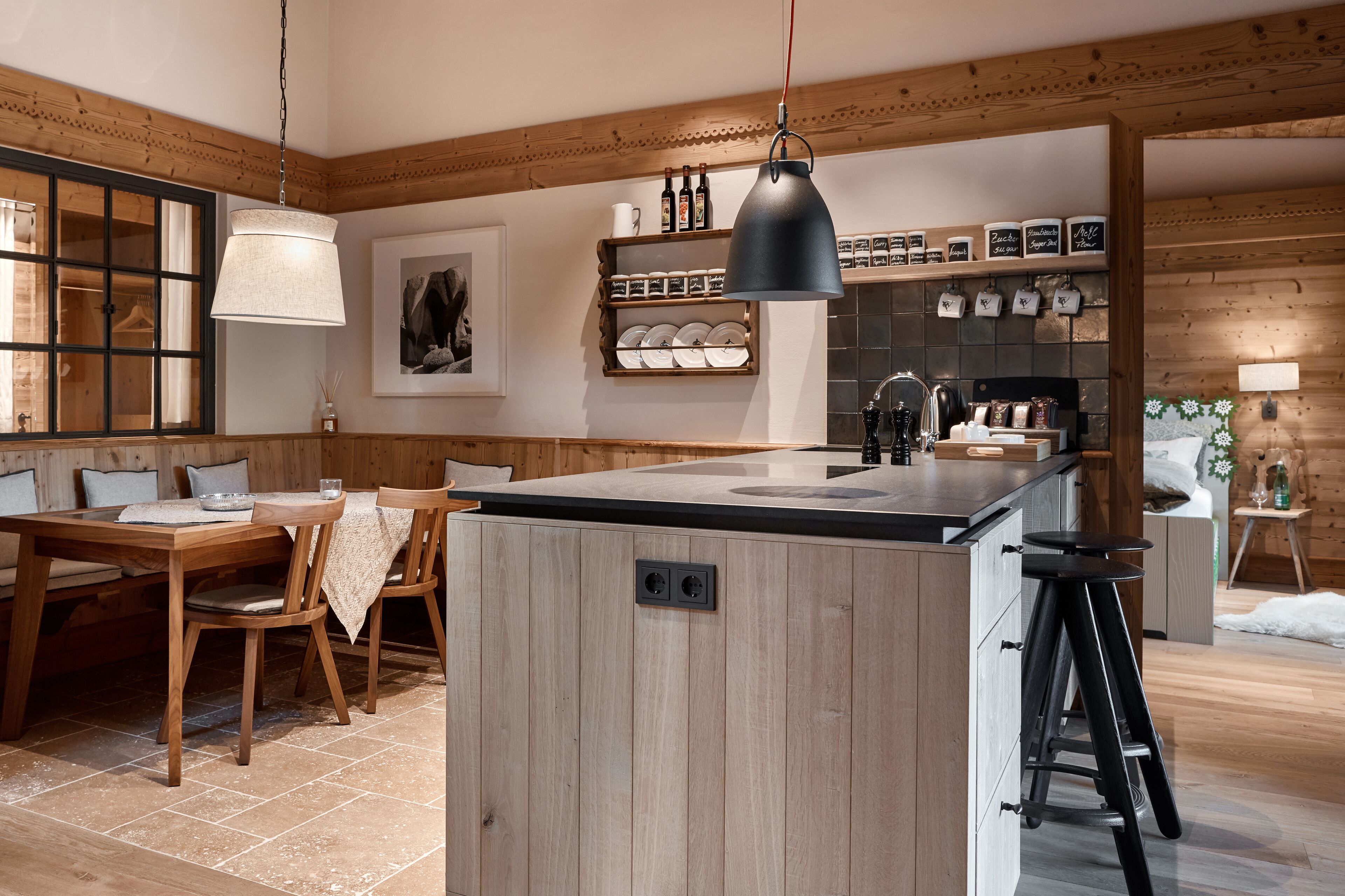 Une cuisine moderne avec des éléments en bois, un îlot central, des tabourets de bar et un luminaire suspendu.