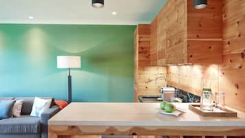 Eine moderne Küche mit Holdekor, einer Marmorarbeitsplatte und einem Essbereich mit Holztisch und Bank.
