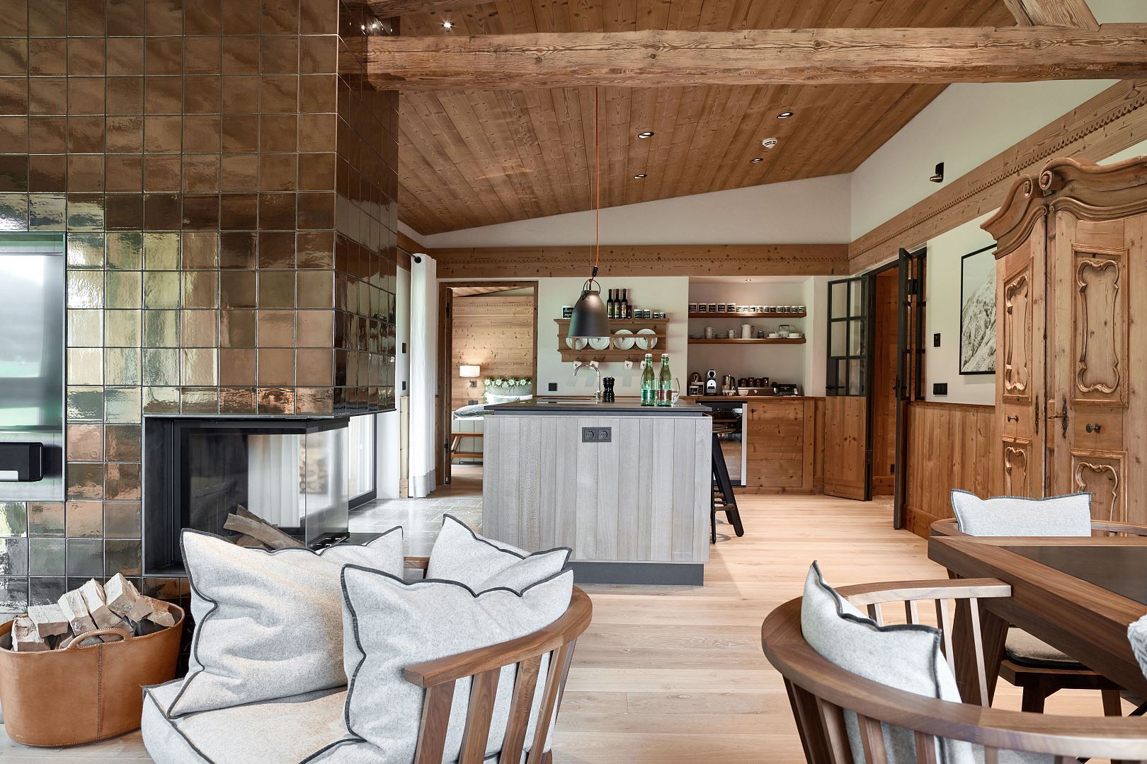 A spacious kitchen with wooden cabinetry, a central island, and a dining area with a wooden table and chairs.