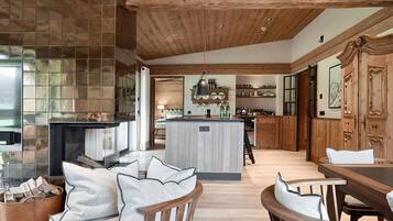 A spacious kitchen with wooden cabinetry, a central island, and a dining area with a wooden table and chairs.