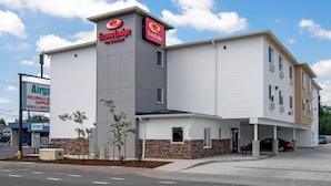 A hotel with a prominent EconoLodge sign, a parking area, and a visible storefront for Airgas. - Econo Lodge Inn & Suites Springfield Main Street (Springfield)