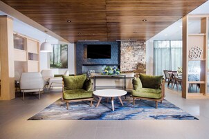 Una sala de estar moderna con chimenea de piedra, un televisor de pantalla plana y un comedor con mesa y sillas.
