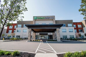 A Holiday Inn Express & Suites hotel entrance with a covered parking area and a clear sky. - Holiday Inn Express & Suites Tonawanda - Buffalo Area by IHG (Tonawanda)