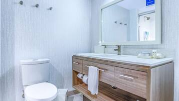 A modern bathroom with a toilet, sink, and vanity.