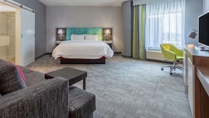 A hotel room with a bed, a desk, a chair, and a TV. - Hampton Inn & Suites Burlington (Burlington)