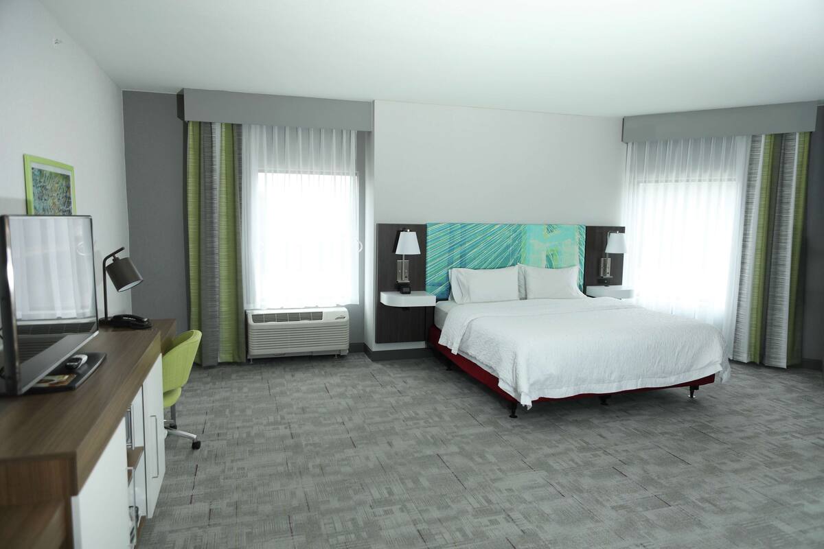Une chambre d’hôtel équipée d’un lit, d’un bureau, d’une chaise et d’un téléviseur.