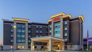 A modern hotel with a brick facade, large windows, and a covered entrance. - Hampton Inn & Suites Burlington (Burlington)