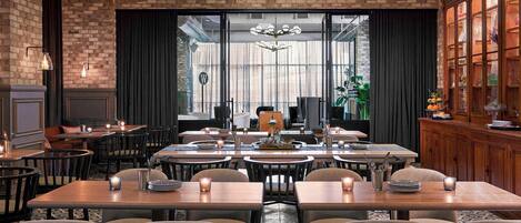 A restaurant with brick walls, modern lighting, and a view of the street.