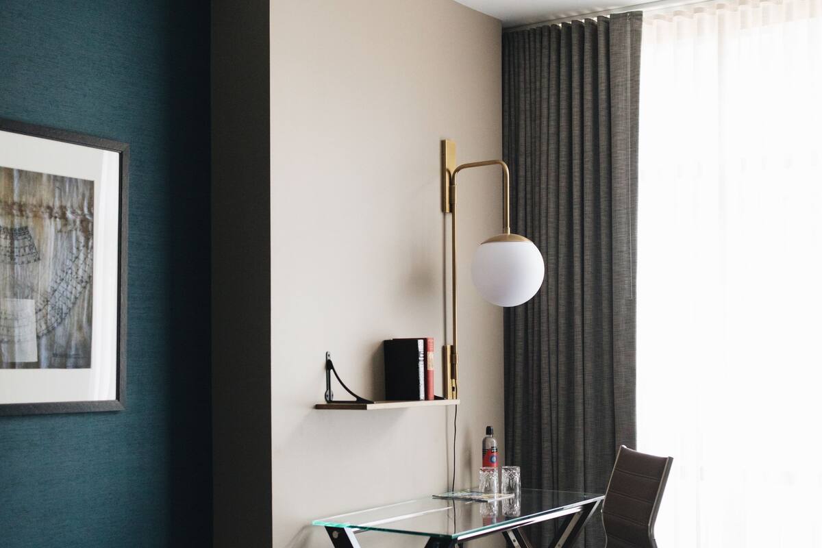Habitación de hotel con escritorio, silla y banca.