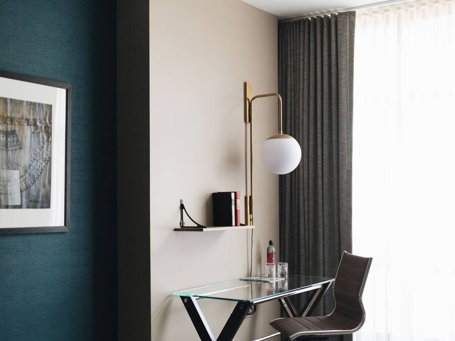 Une chambre d’hôtel équipée d’un bureau, d’une chaise et d’un banc.