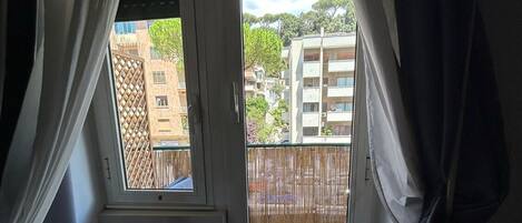 Una habitación con vistas a un balcón, un radiador y una silla roja.