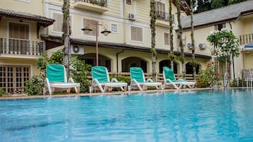 Una piscina al aire libre, tumbonas