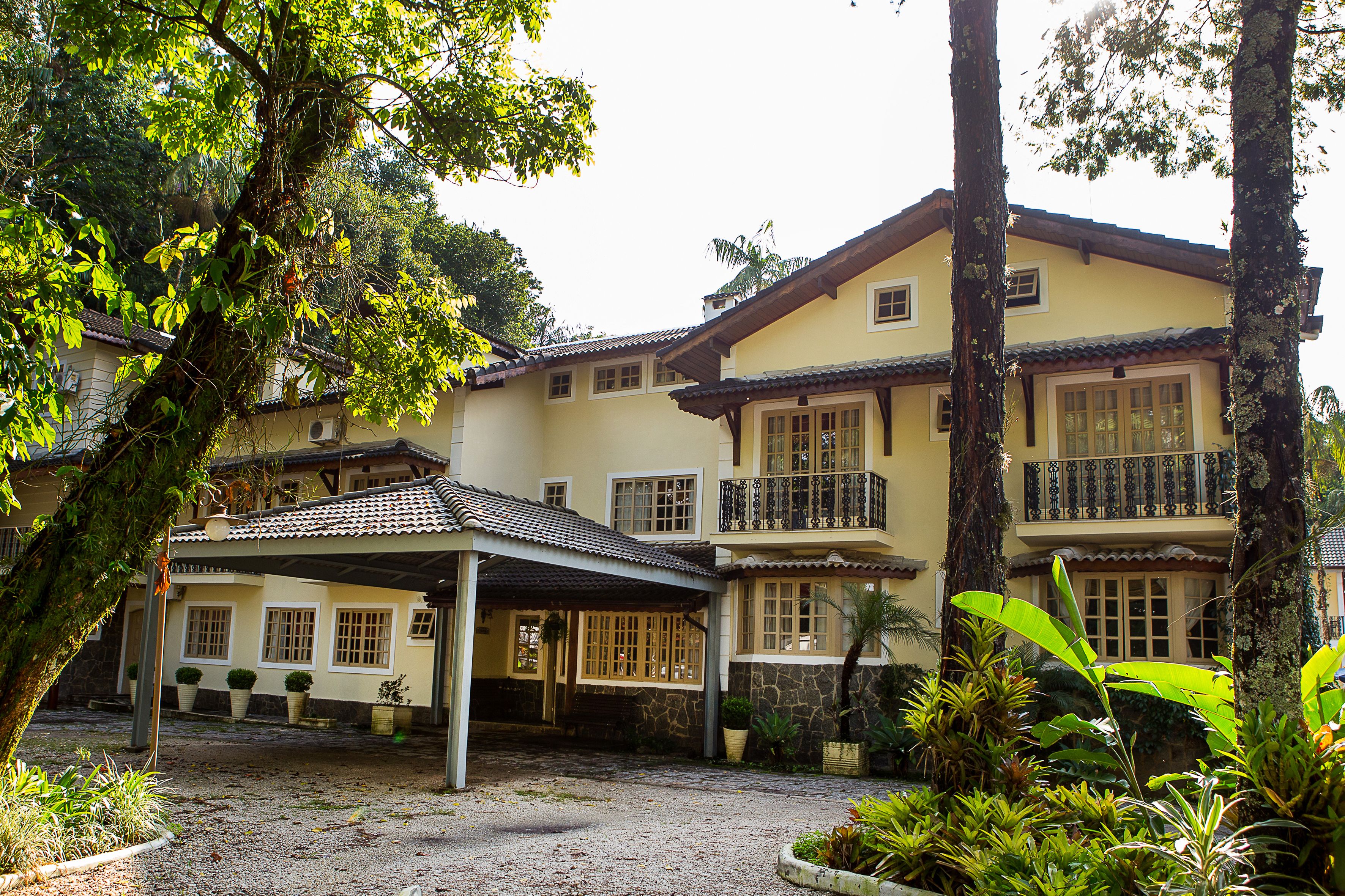 A two-story building with a covered patio, stone walls, and multiple windows.