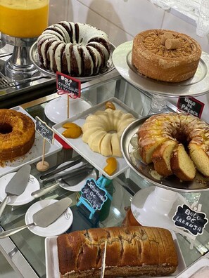 A bakery display with various cakes and pastries. - Hotel Rio Penedo (Itatiaia)