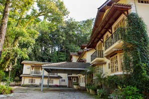 A traditional building with a tiled roof, multiple balconies, and a covered entrance area. - Hotel Rio Penedo (Itatiaia)