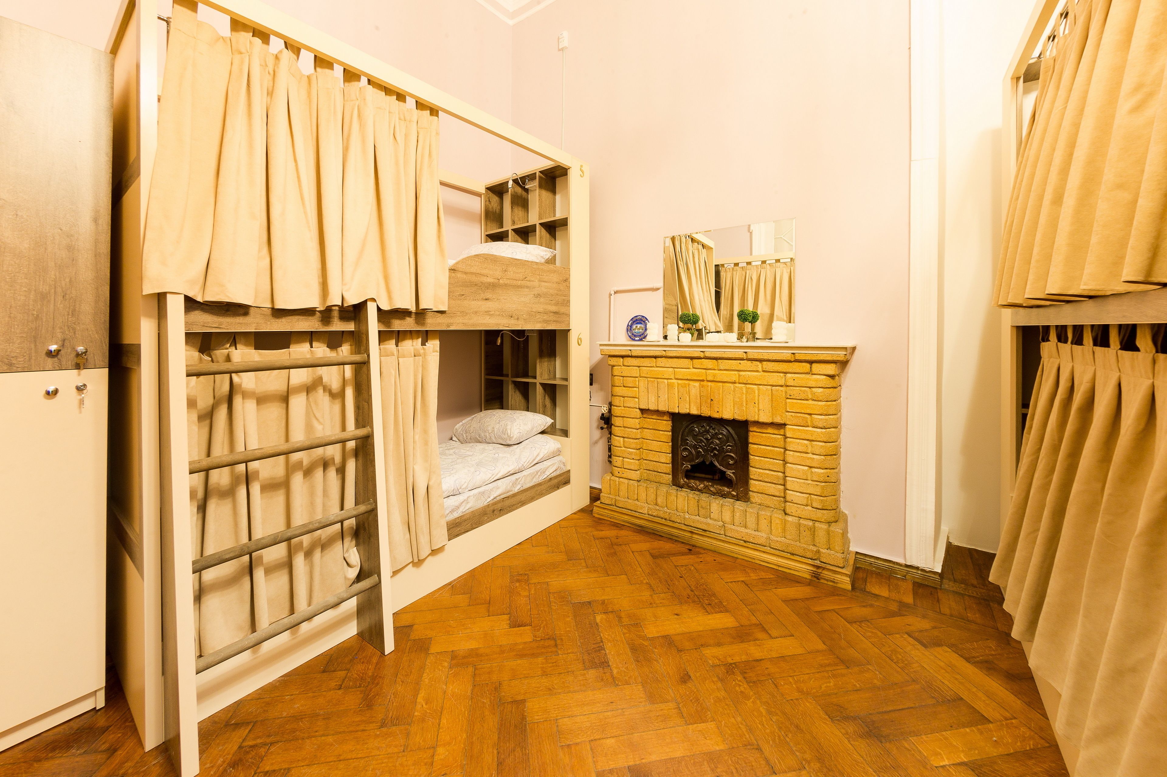 A room with a bunk bed, a fireplace, and a mirror above it.