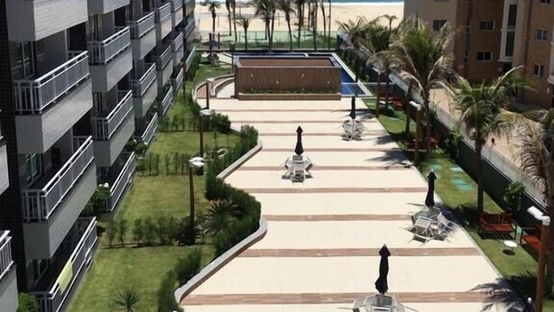 Un hotel de varios pisos, con zonas de estar al aire libre y vistas a la playa.