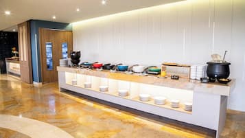 A modern breakfast bar with a variety of dishes and a coffee station.
